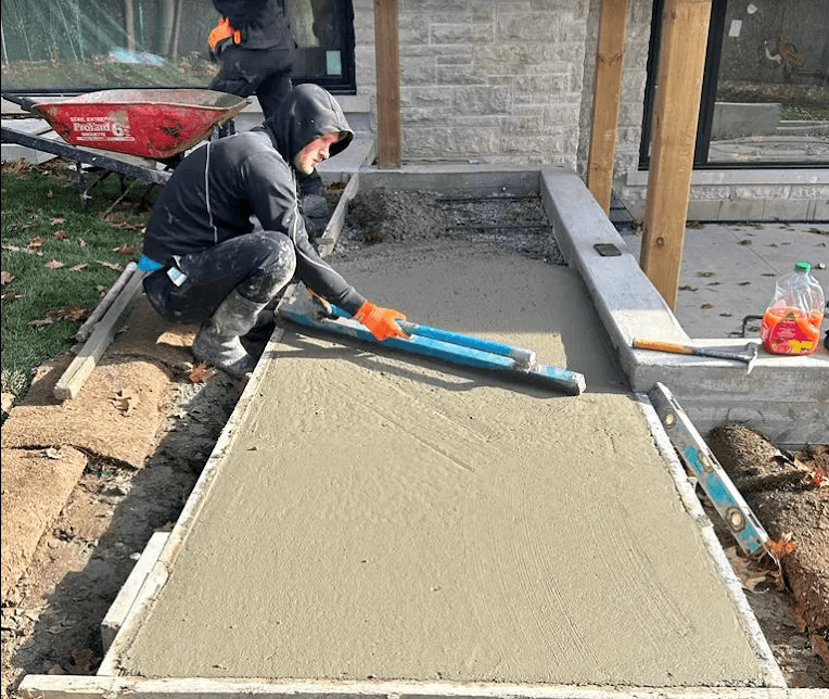 Nashville Concrete Solutions crew finishing a concrete pour outside a home